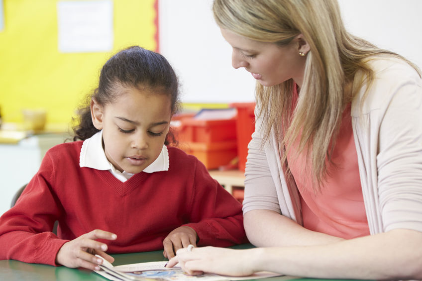 Image of teacher helping child with schoolwork