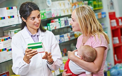 A pharmacist assisting a parent with a small child